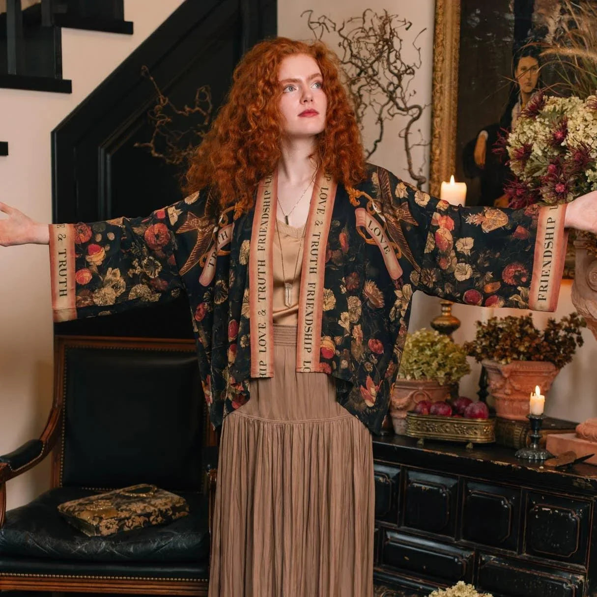 Woman in floral kimono with 'Love & Truth Friendship' ribbons, vintage home décor, candles, dried flowers