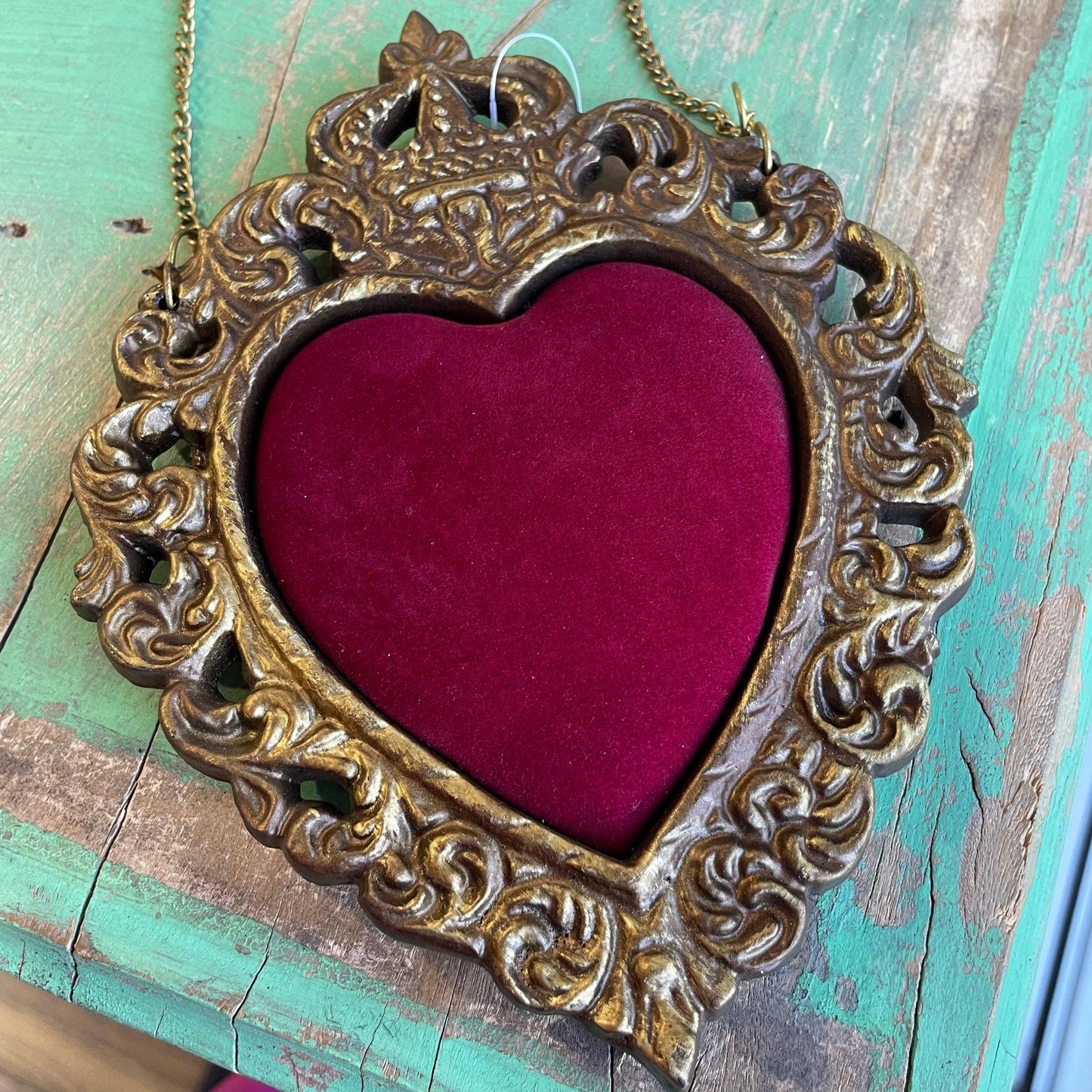 Ornate gold heart frame with a red velvet center