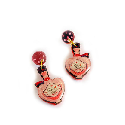 Heart-shaped perfume bottle earrings on a white background
