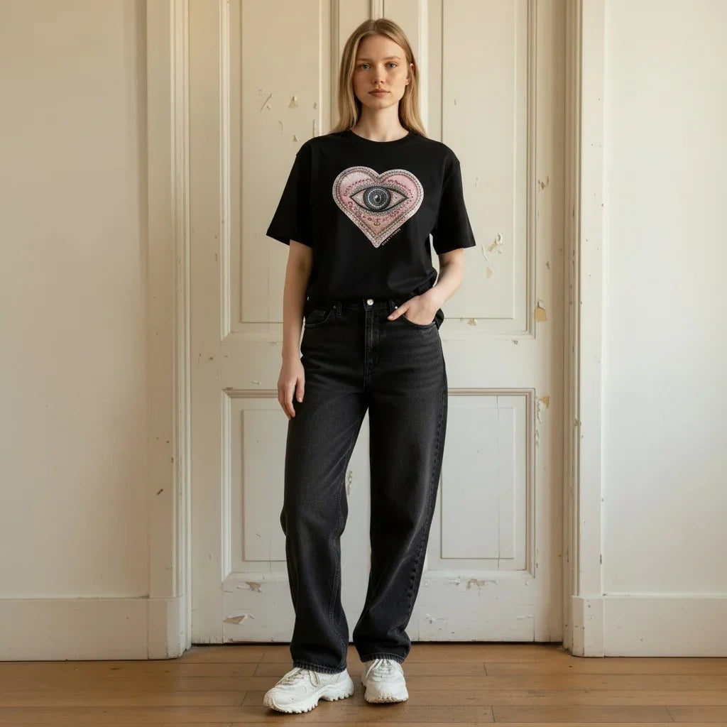 Woman wearing Bespoke Hearts The Lover’s Eye black t-shirt and dark grey jeans.
